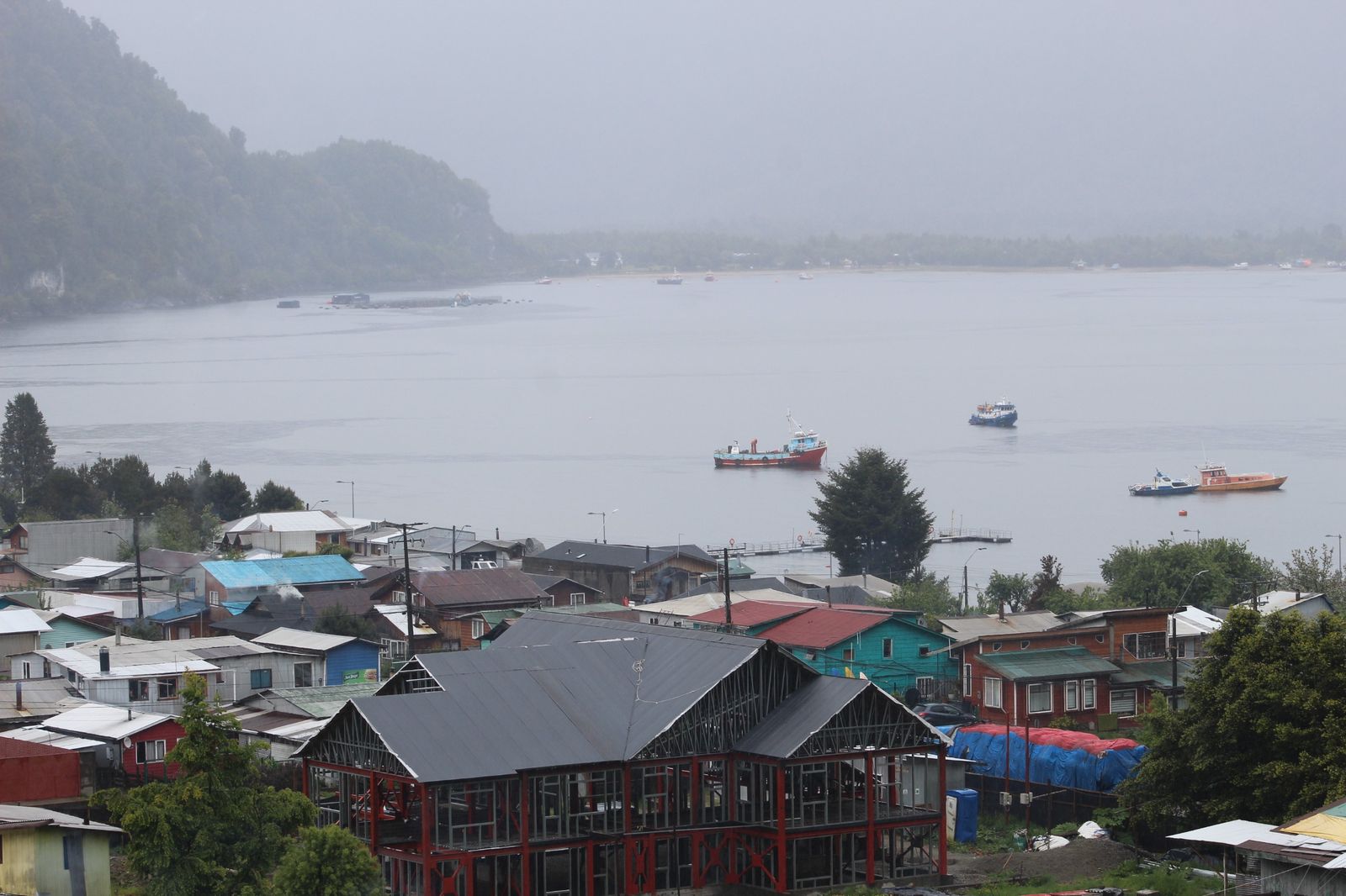 Puerto de Aysén un día de lluvia, con lanchas en la bahía